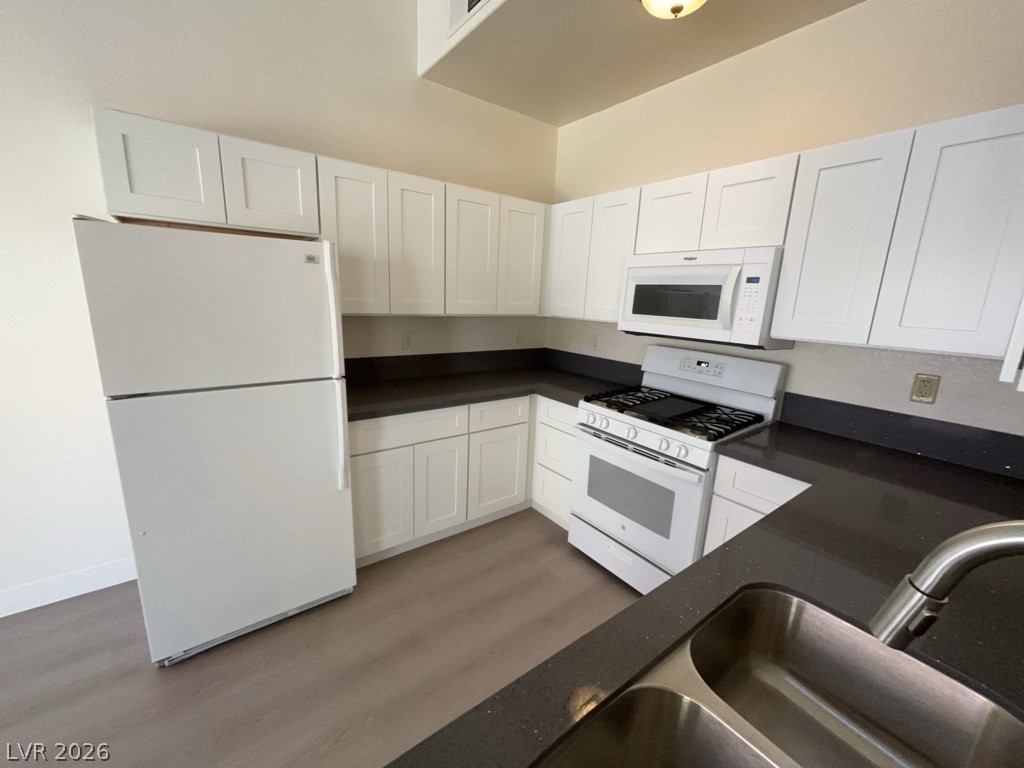 4915 East Russell Road, Unit 147 Las Vegas, NV 89120 - Photo 7 of 14 Kitchen featuring white appliances, white cabinets, and light wood-style flooring