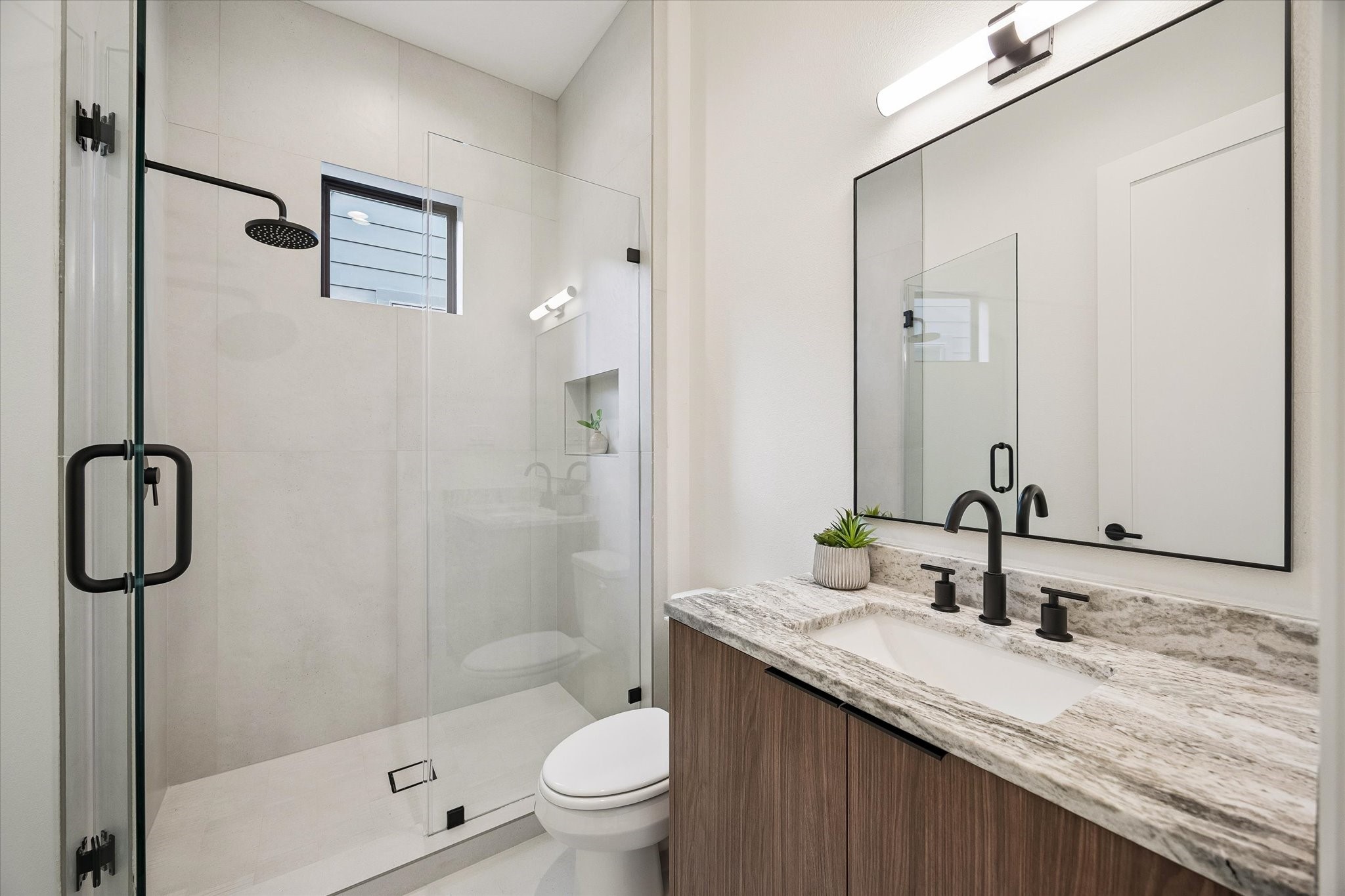 335 Harvard Street Houston, TX 77007 - Photo 27 of 35 En-suite bath #5 - features a walk-in shower with frameless glass shower door.