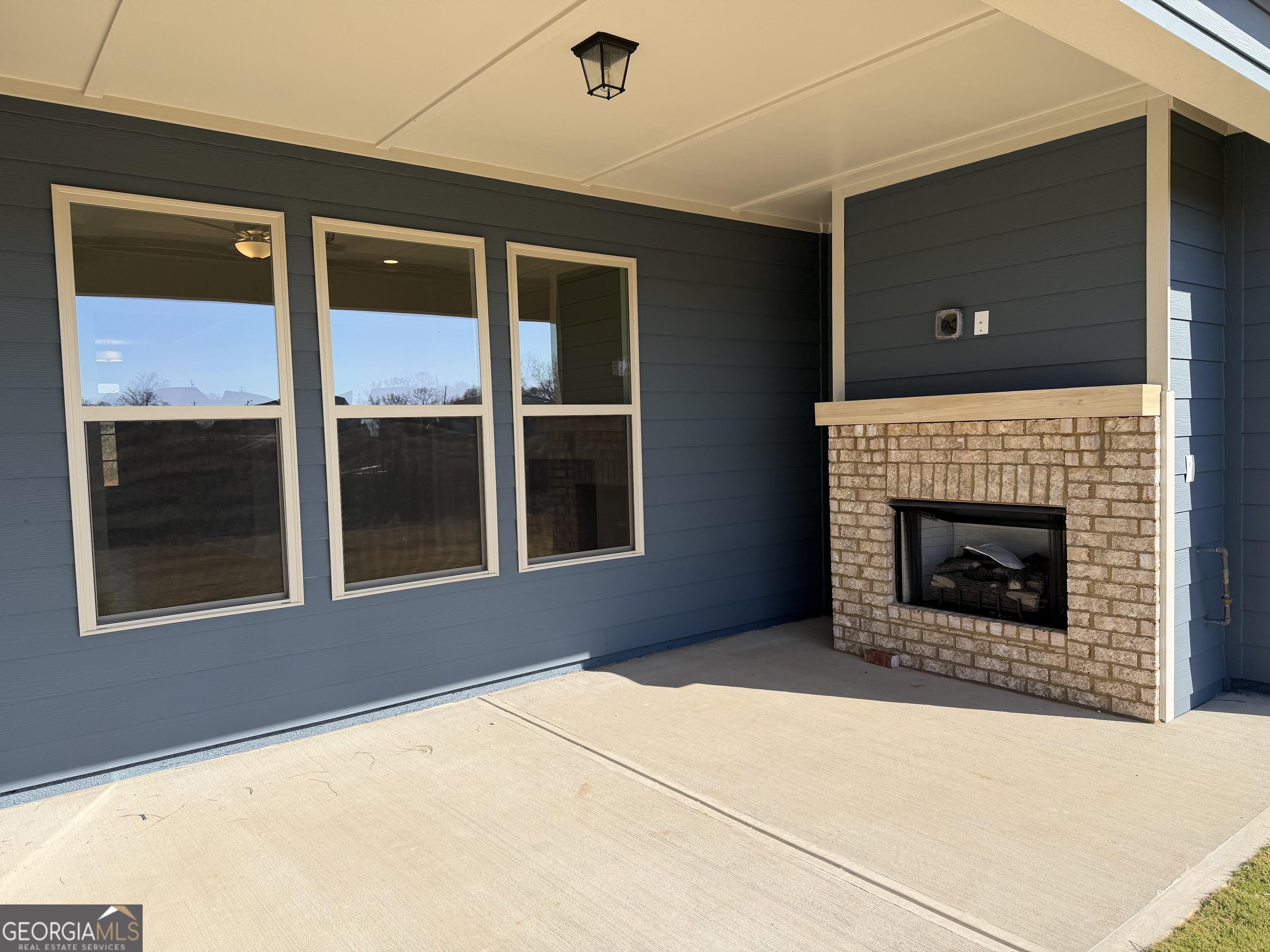 233 Oakdale Road, Unit 53 Jefferson, GA 30549 - Photo 19 of 64 Very large covered patio with a gas fireplace, cedar beam mantle, ready to watch your favorite games. The ceiling is braced and wired for a ceiling fan.