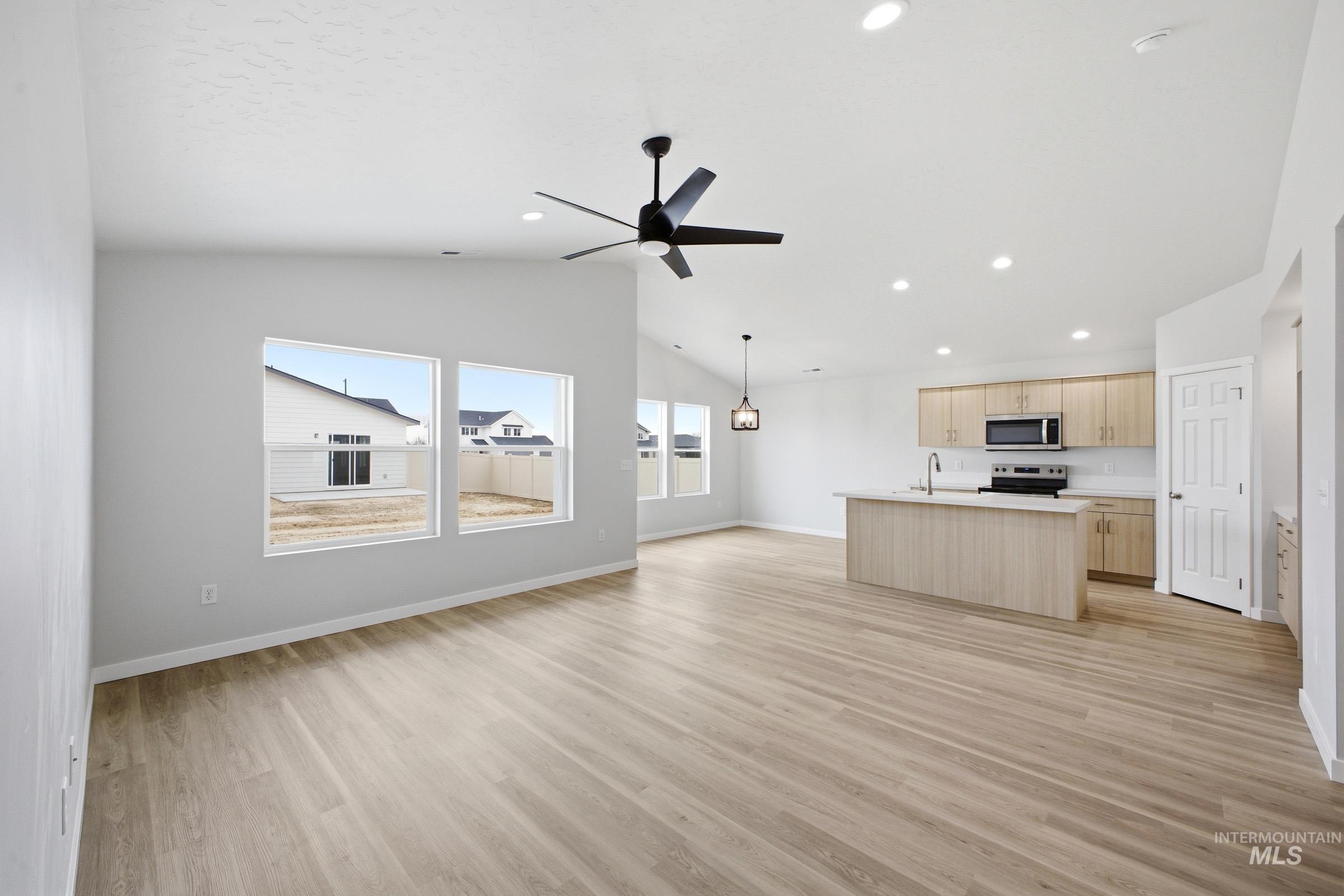 1598 Sunday River Street Middleton, ID 83644 - Photo 9 of 17 Open-concept living area featuring light wood-finish flooring, vaulted ceilings, and recessed lighting