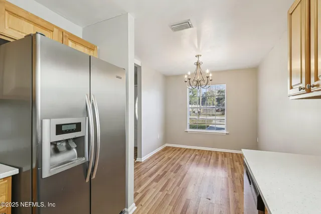 a view of a kitchen with a refrigerator cabinet and windows