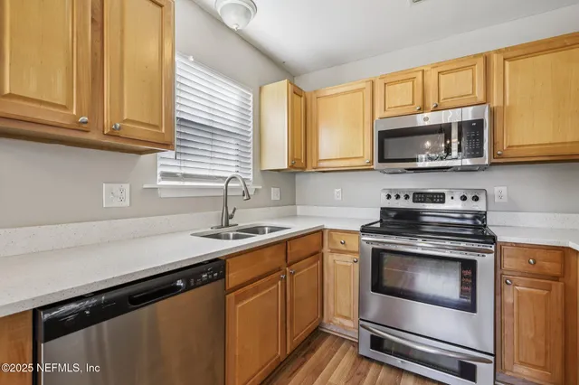 a kitchen with granite countertop a sink stove and microwave