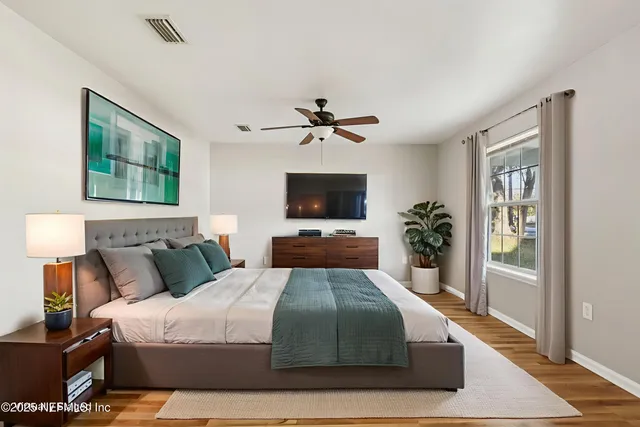a bedroom with a large bed and a chandelier