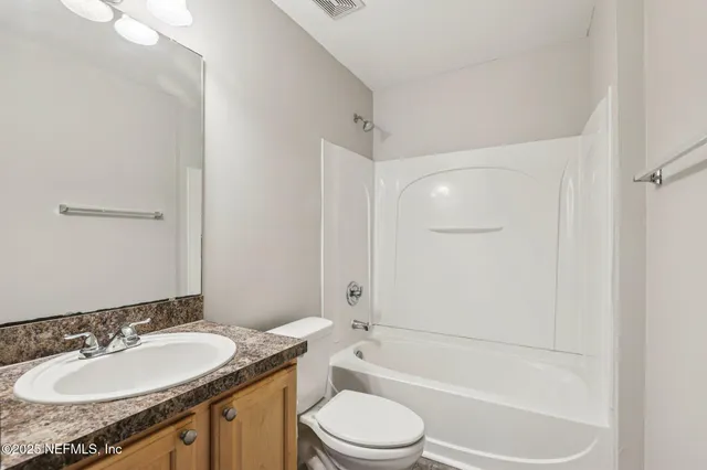 a bathroom with a granite countertop sink toilet mirror and shower