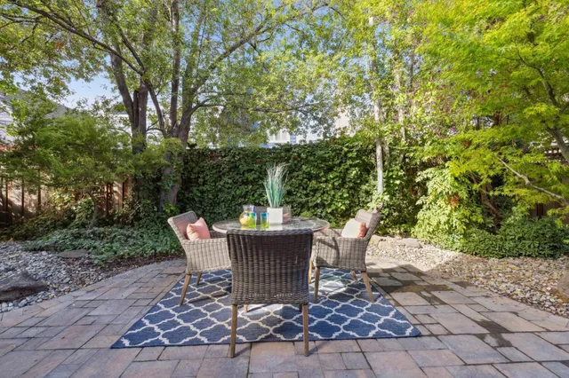 a view of a table and chairs in back yard of the house