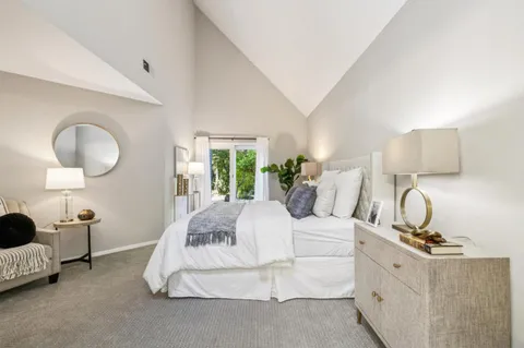 a spacious bedroom with a bed and lamp