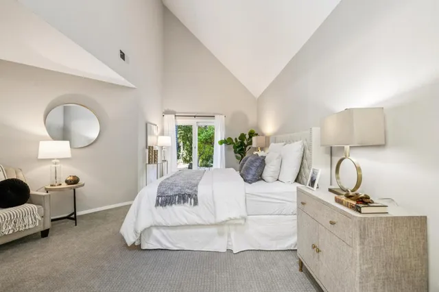 a spacious bedroom with a bed and lamp