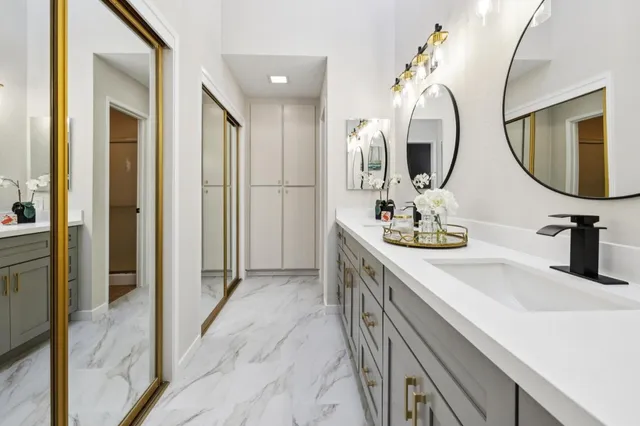 a bathroom with double vanity sinks and a mirror