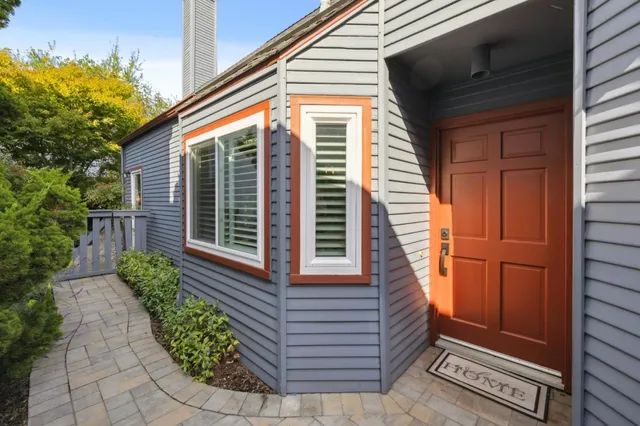 a view of a house with a small window and potted plants