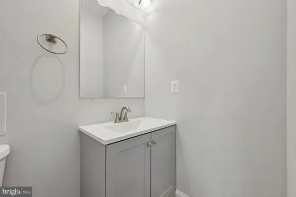 a bathroom with a granite countertop sink mirror vanity and toilet