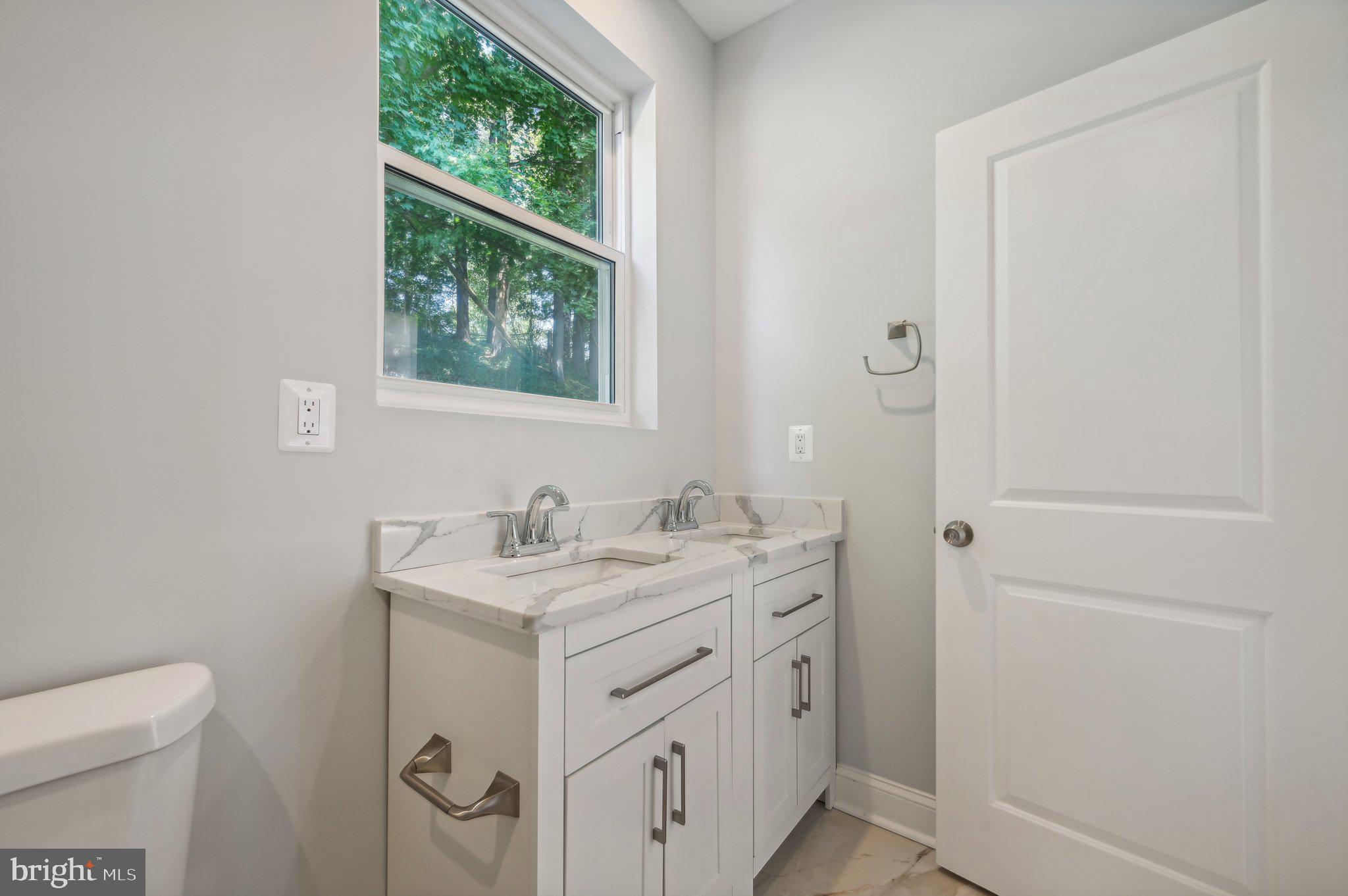 2430 Harris Mill Road Parkton, MD 21120 - Photo 31 of 68 a bathroom with a granite countertop sink a toilet and a window
