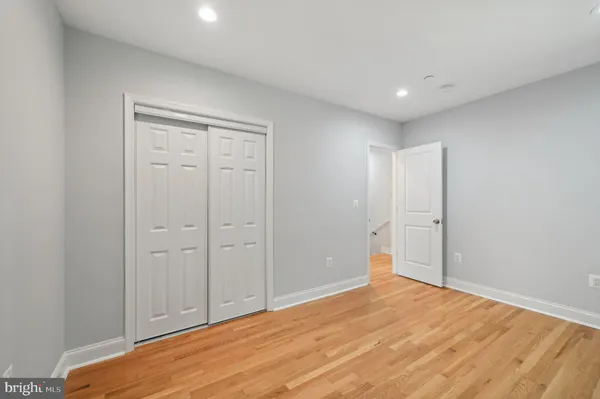 a view of an empty room with wooden floor and stairs