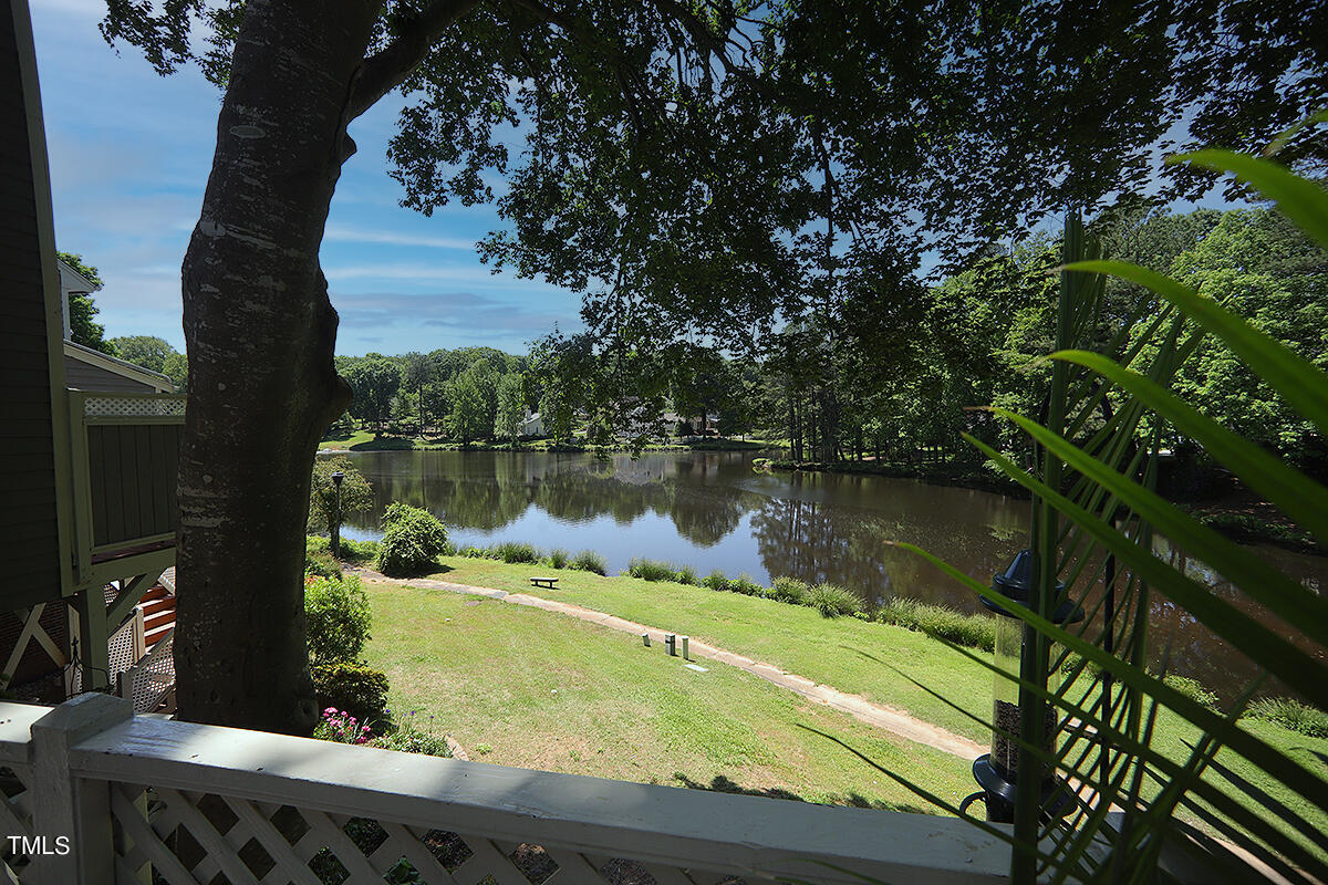 a view of a lake with a yard from a balcony
