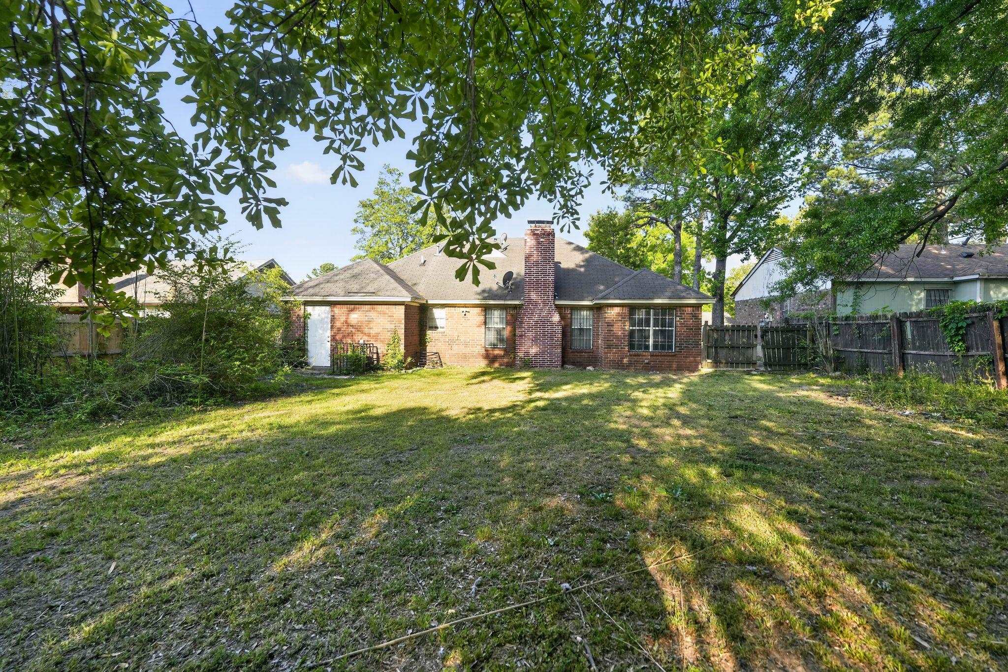 3820 Clarke Road Memphis, TN 38115 - Photo 29 of 30 Rear view of house with a fenced backyard, a chimney, and brick siding