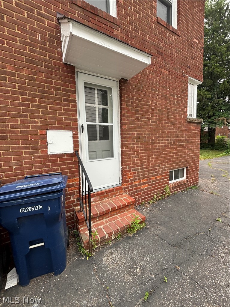 3830 Berkeley Road Cleveland Heights, OH 44118 - Photo 2 of 27 Brick exterior featuring a white entry door with an overhead awning