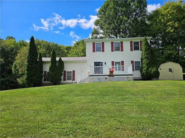 a view of a house with backyard and sitting area
