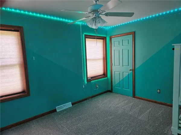 a view of empty room with window and fan