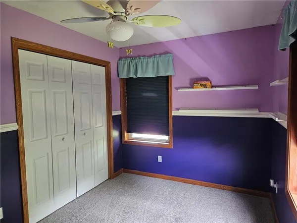 an empty room with closet and fan