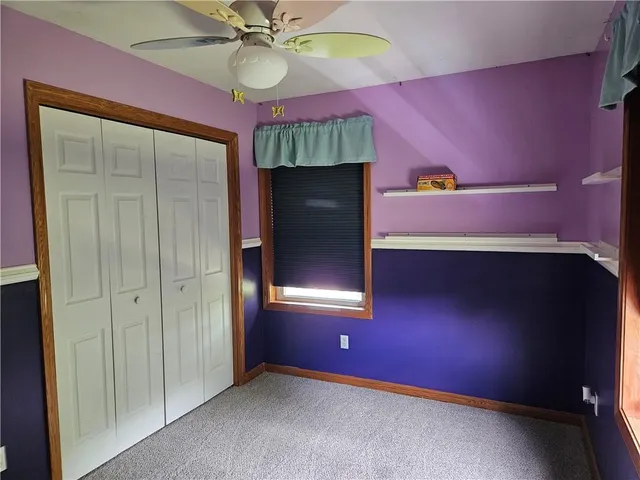 an empty room with closet and fan