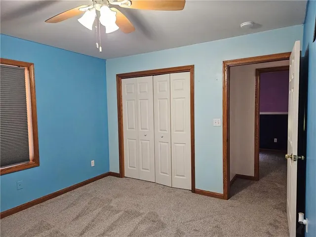 a view of an empty room and chandelier fan
