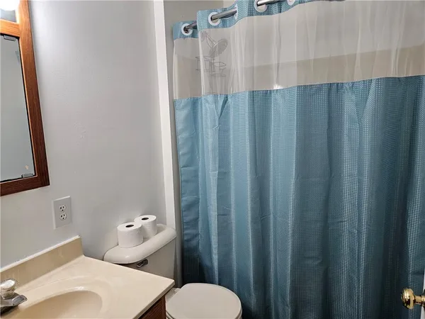 a bathroom with a sink a toilet and shower curtain
