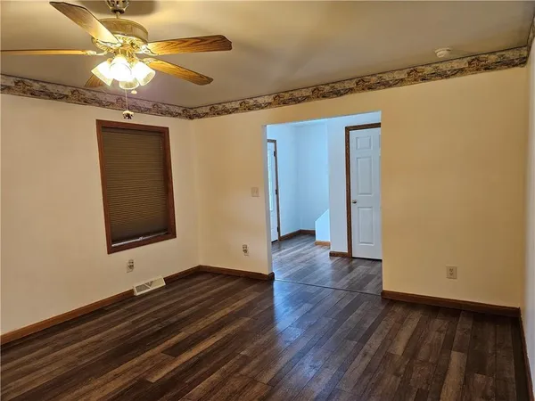 a view of an empty room with wooden floor