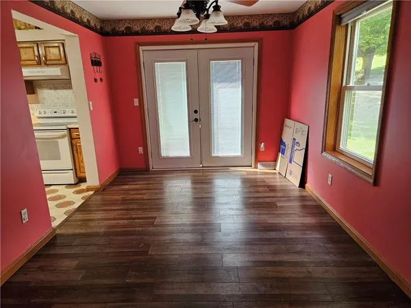 a view of a hallway with wooden floor and a window