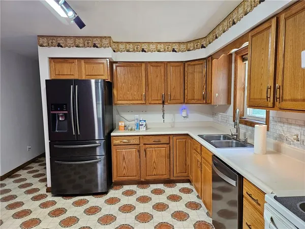a kitchen with stainless steel appliances granite countertop a sink a stove a refrigerator and cabinets