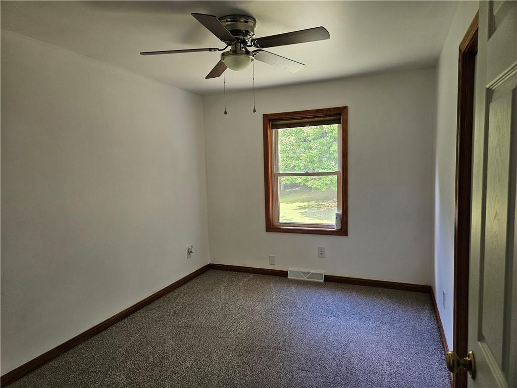 7715 Lamor Road Mercer, PA 16137 - Photo 10 of 30 an empty room with a ceiling fan and a window