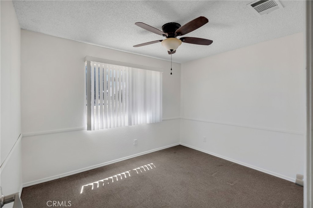 12736 Oasis Road Pinon Hills, CA 92372 - Photo 18 of 33 an empty room with a window and a fan