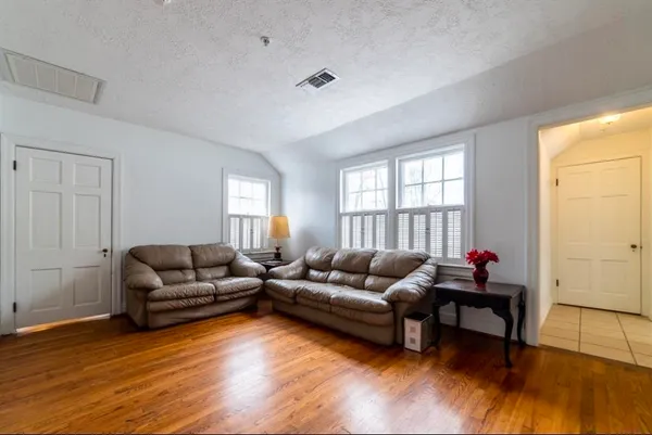 a living room with furniture and a wooden floor