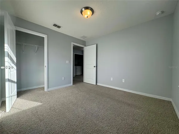 an empty room with windows and closet