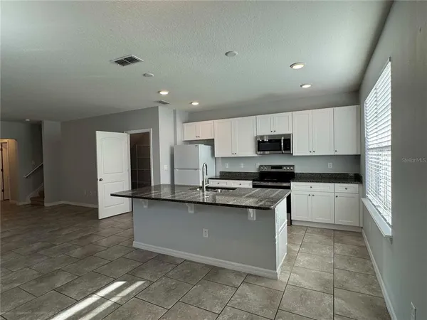 a kitchen with stainless steel appliances a sink stove and cabinets