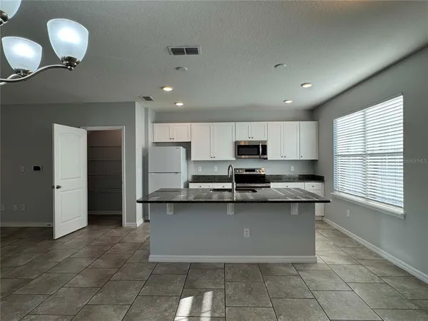 a view of a kitchen with a refrigerator and a cabinets