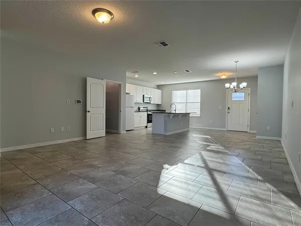 a view of kitchen living space with kitchen island wooden floor and living room