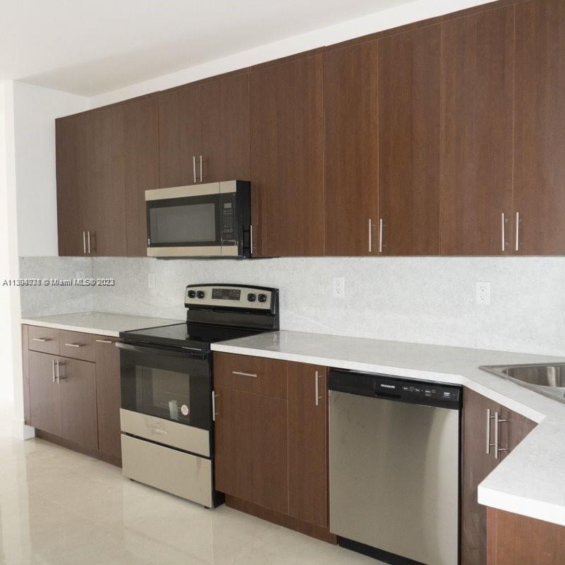 Blanche Ely Pompano Beach, FL 33060 - Photo 11 of 24 a kitchen with cabinets and steel stainless steel appliances