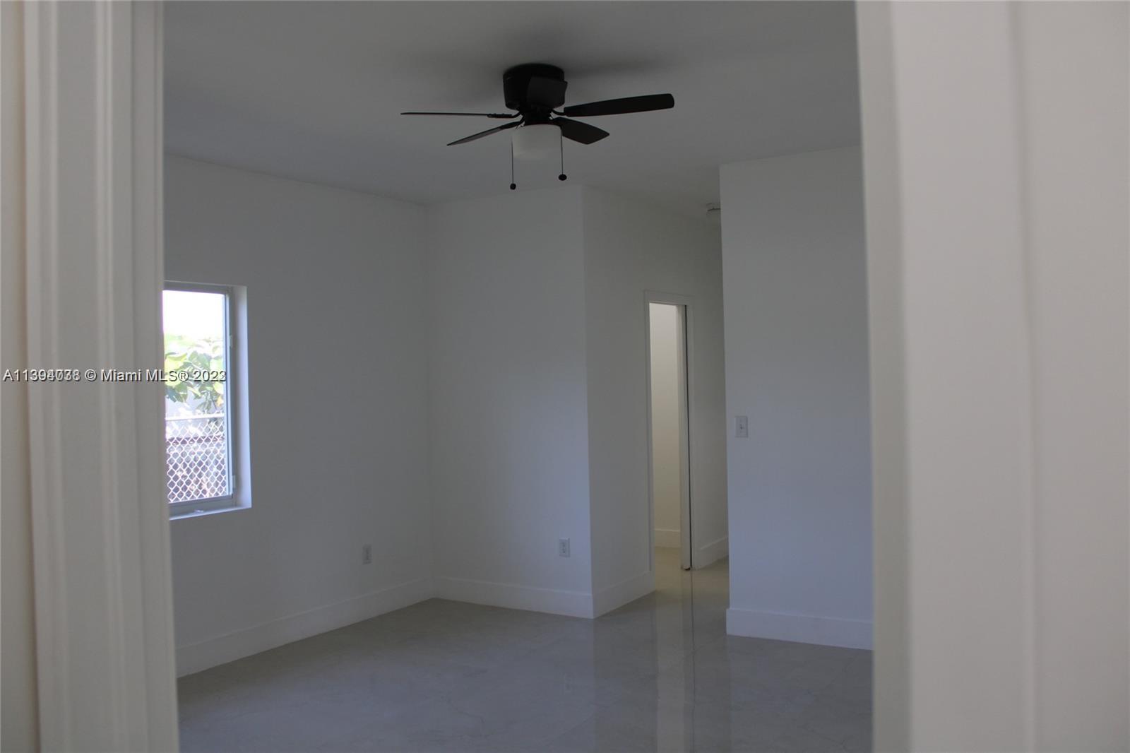 Blanche Ely Pompano Beach, FL 33060 - Photo 23 of 24 an empty room with windows and a ceiling fan