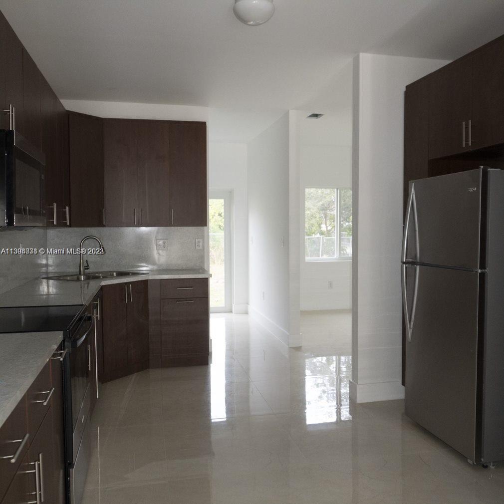 Blanche Ely Pompano Beach, FL 33060 - Photo 9 of 24 a kitchen with a refrigerator and a sink