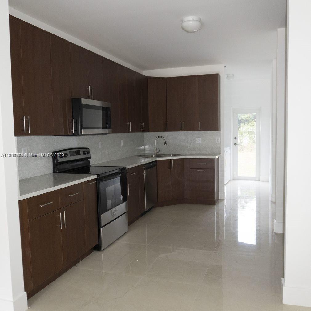 Blanche Ely Pompano Beach, FL 33060 - Photo 10 of 24 a kitchen with a sink and a stove top oven