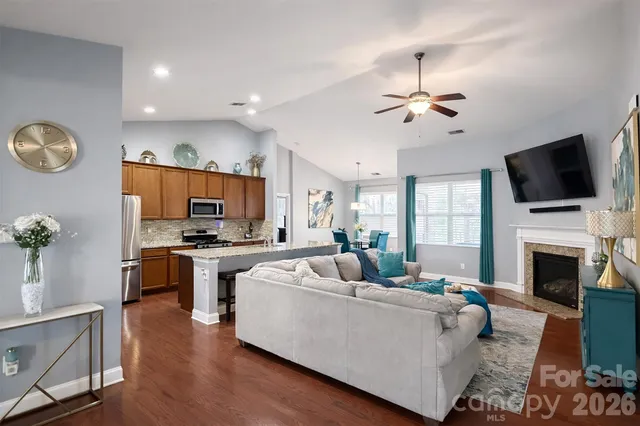a living room with furniture a fireplace and a flat screen tv