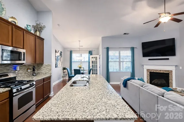 a open kitchen with a sink a fireplace and cabinets