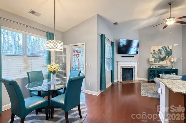 a living room with furniture potted plant and open kitchen view