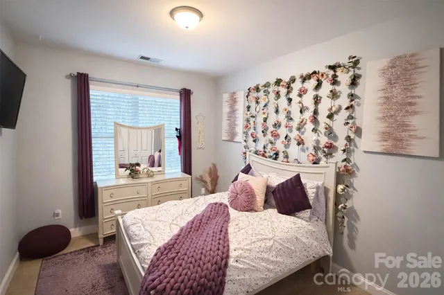 a bedroom with a bed tv and a window