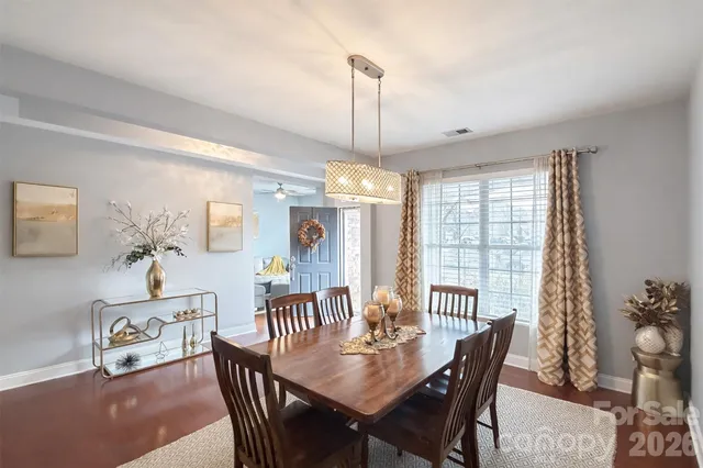 a dining room with furniture a chandelier and wooden floor