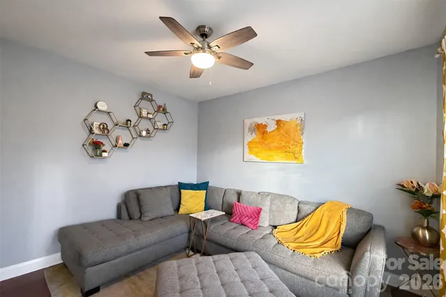 a living room with furniture wooden floor and a large window