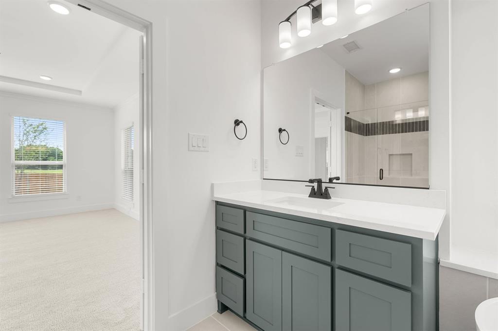 413 Tower Street DeSoto, TX 75115 - Photo 20 of 30 a bathroom with a sink a toilet a large mirror and shower