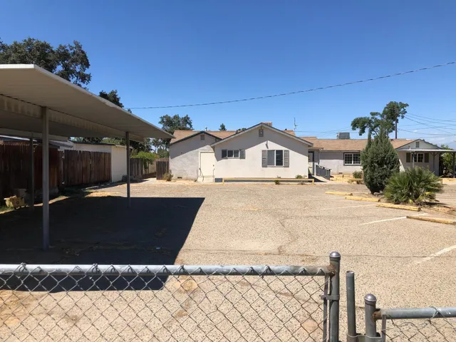 a view of a white house with a yard