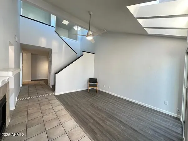 a view of an empty room with wooden floor and a fireplace