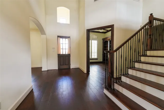 a view of a hallway with wooden floor and stairs