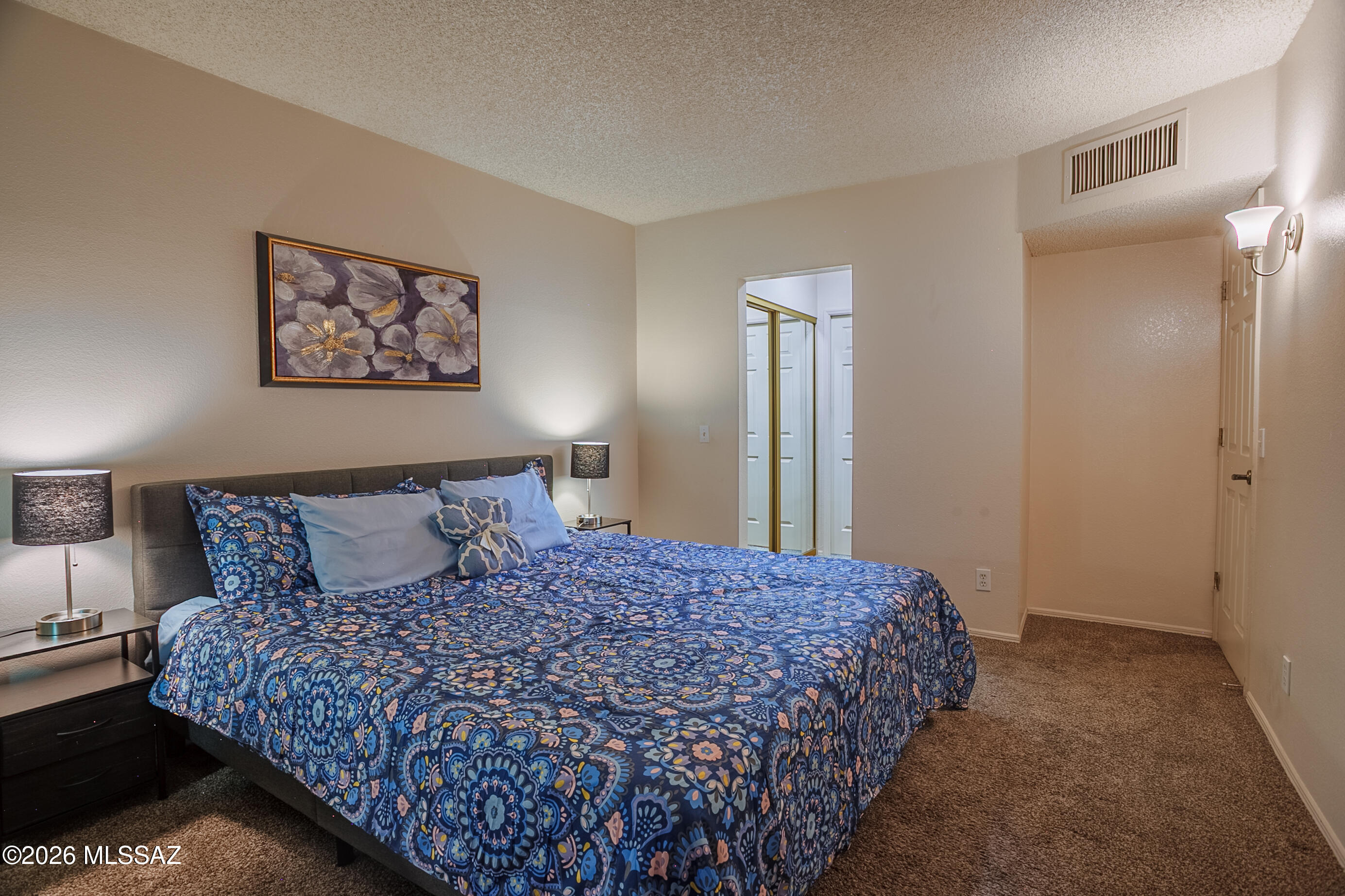 1200 East River Road, Unit B27 Tucson, AZ 85718 - Photo 24 of 40 a large bed sitting in a bedroom next to a window